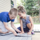 Kids installing NewTechWood deck tiles.