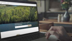 close up of hands scrolling on a laptop through a homepage of a website